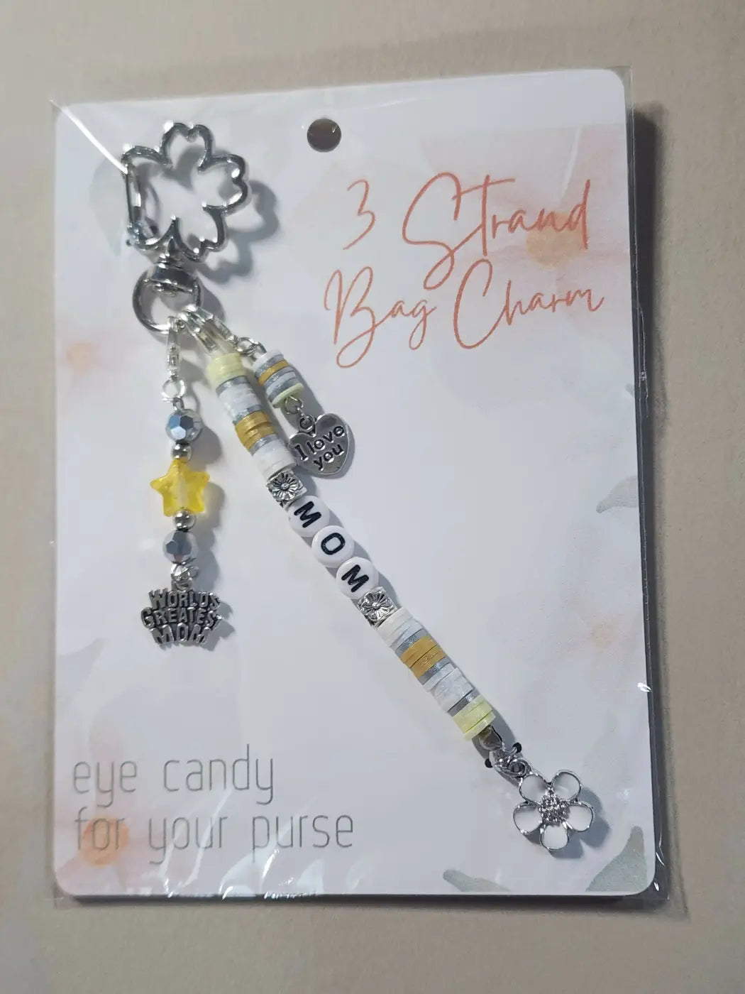 Silver floral bag charm with three strands of beads and mom bead centerpiece, ideal for canadian made skincare gifts