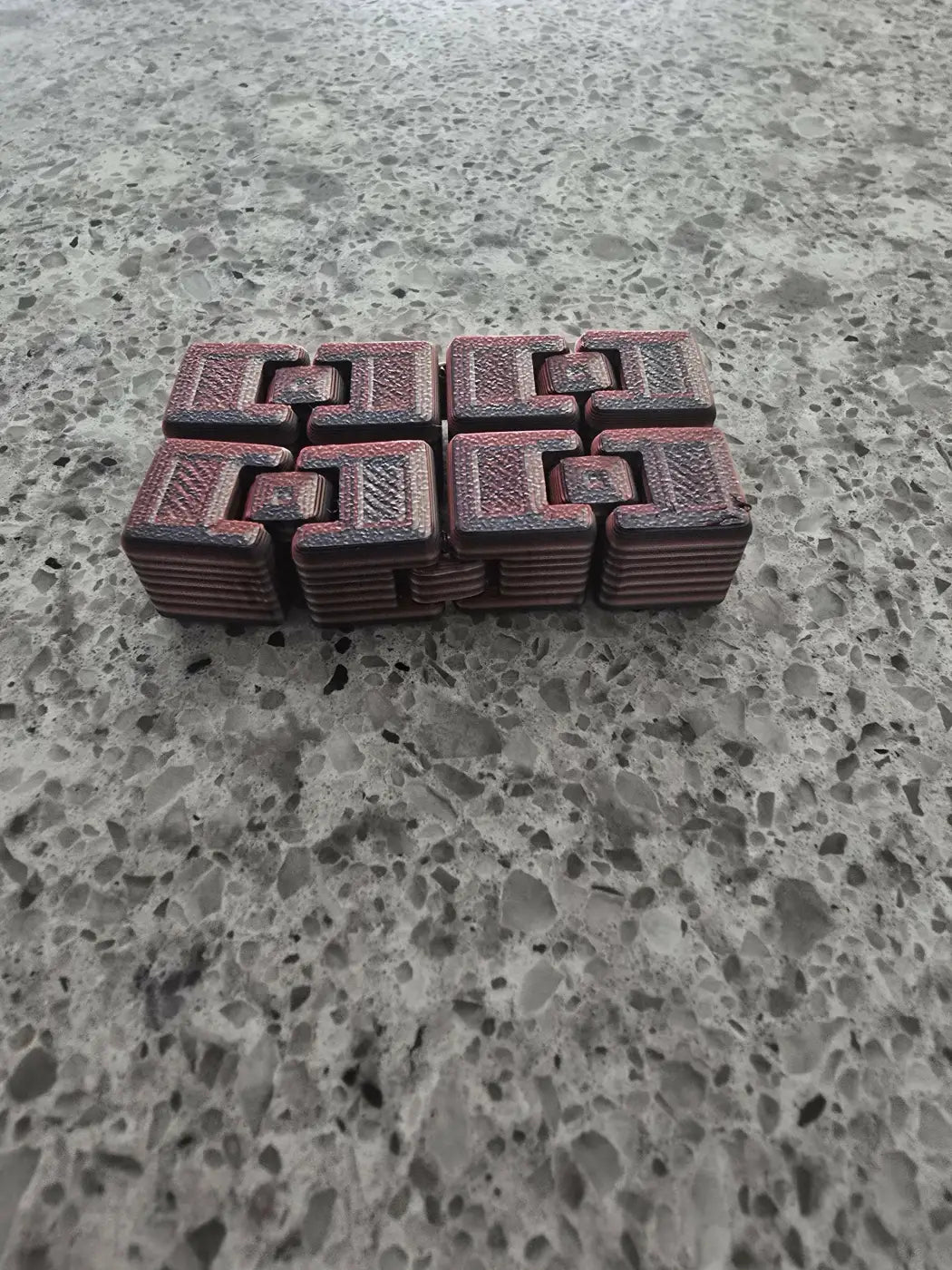 Red textured figet cube with interlocking geometric patterns crafted for stress relief and focus enhancement