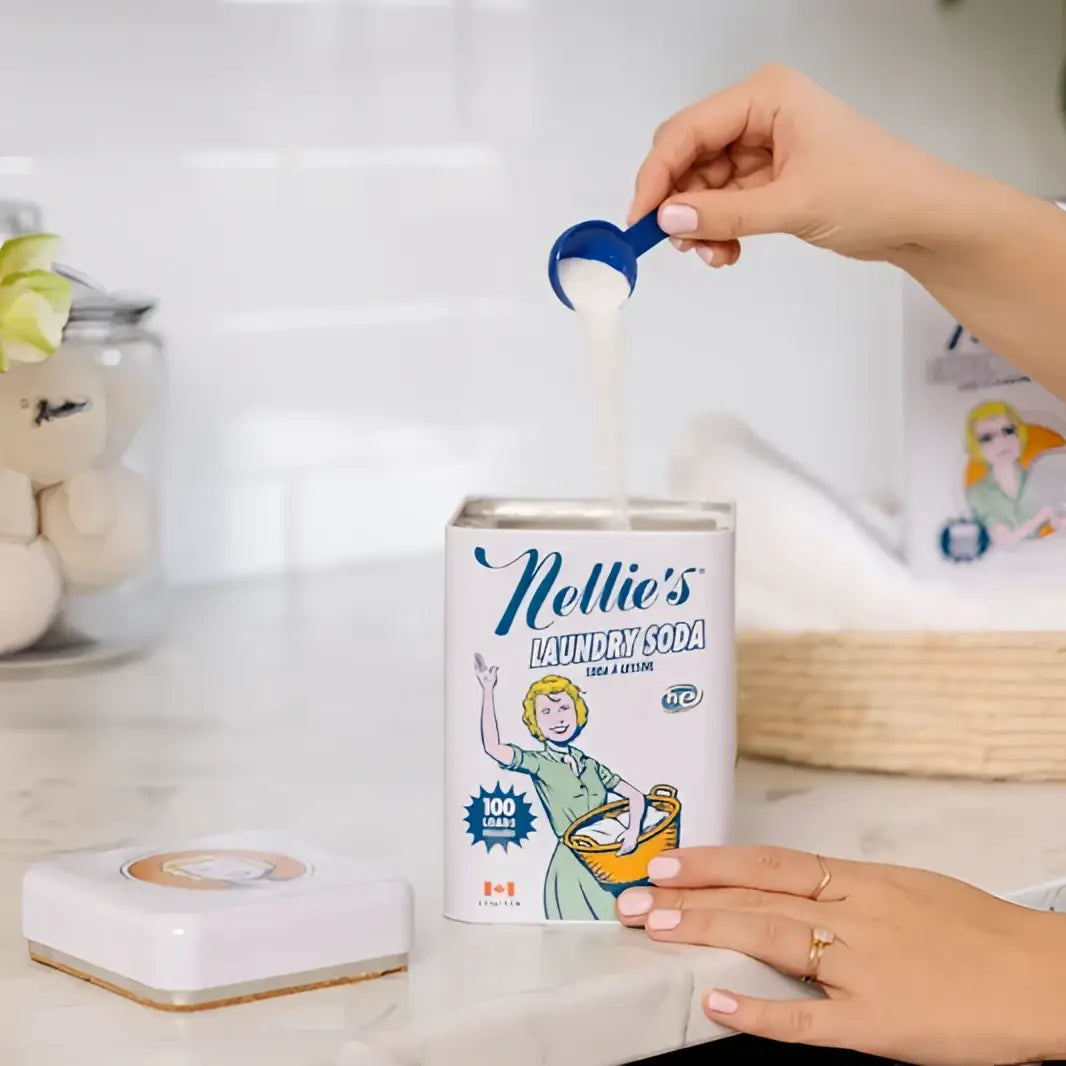 A white rectangular can of nellies laundry soda with blue text and scoop for in-store refill by canadian made skincare