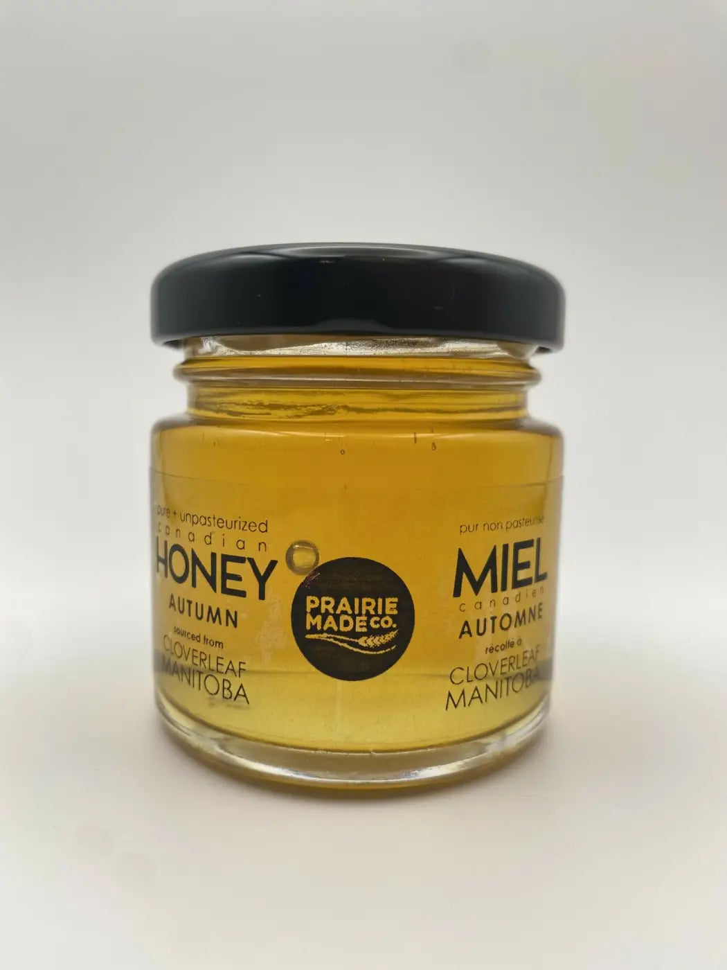 A clear glass jar of golden autumn cloverleaf honey from manitoba by prairie made co in prairie made season honey sampler