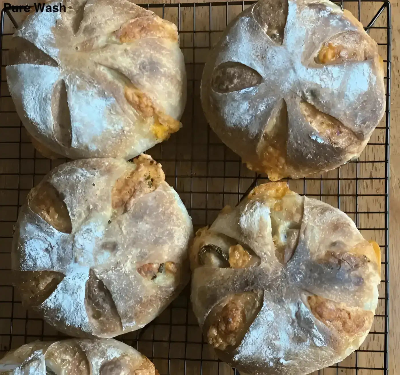 Golden brown original sourdough signature loaf with crosshatch scoring and bread flour dusting available for pre order