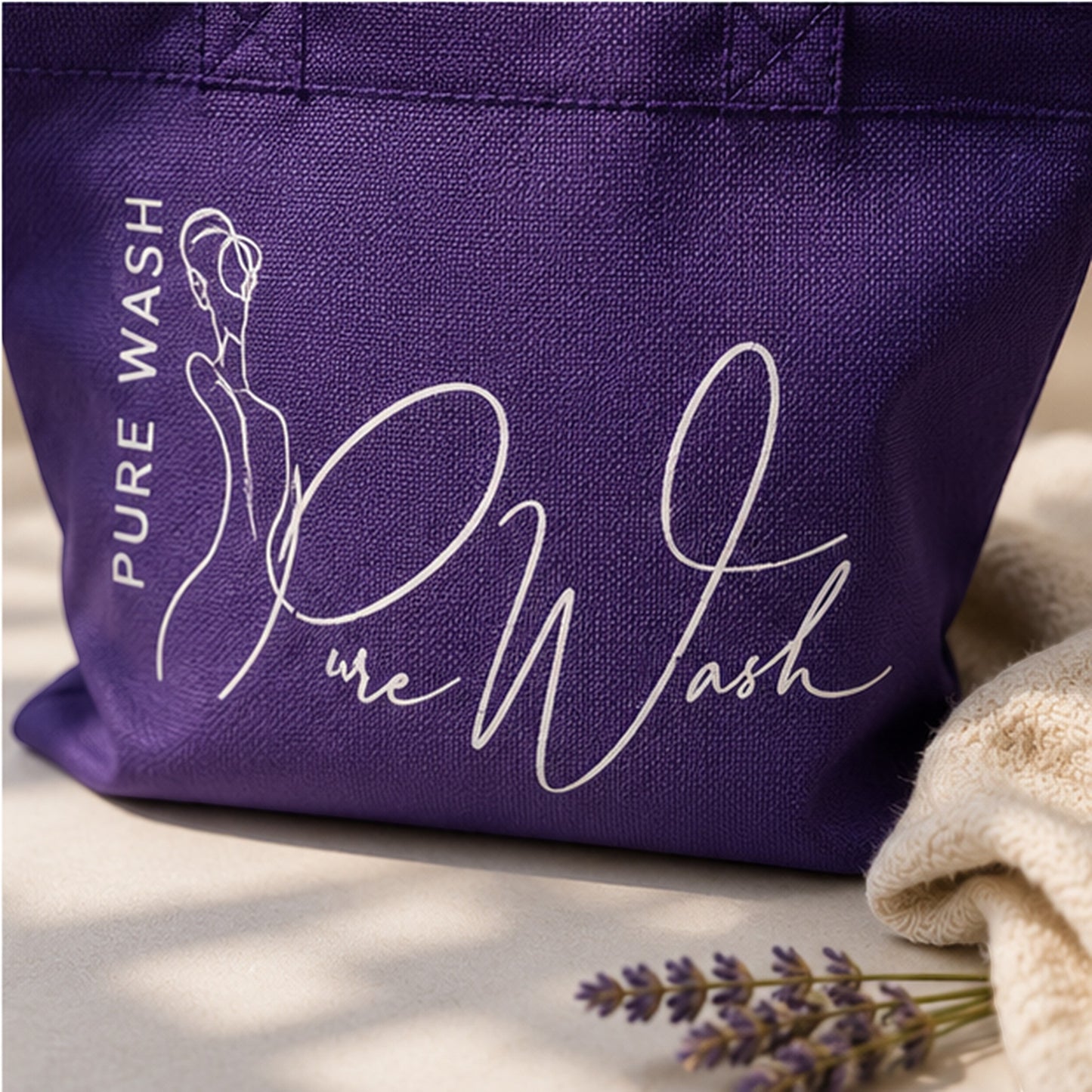 Pure Wash purple reusable tote bag with white logo branding next to a towel and lavender sprig