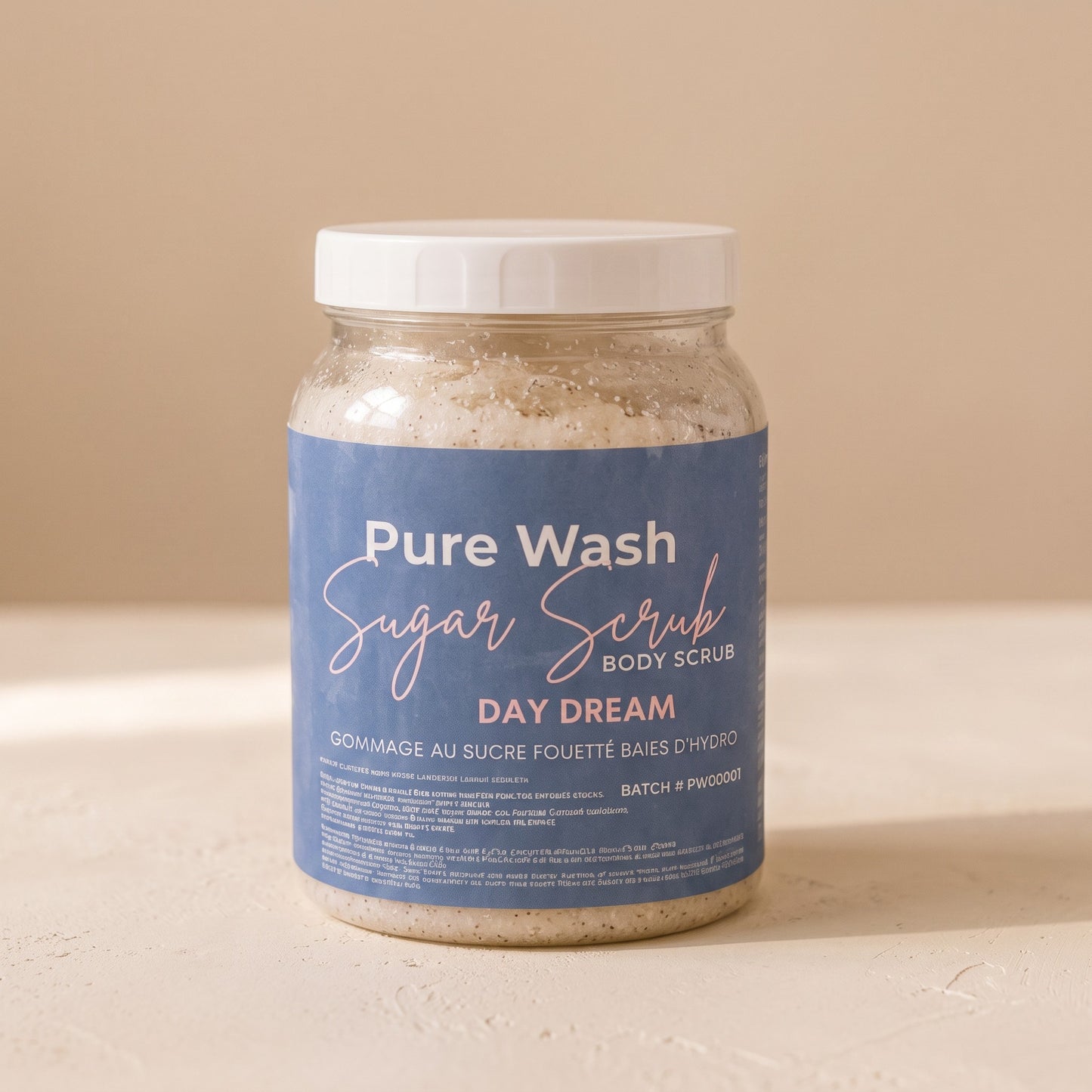Pure Wash Day Dream sugar body scrub in a clear plastic jar with a blue label, featuring coconut and vanilla scent.