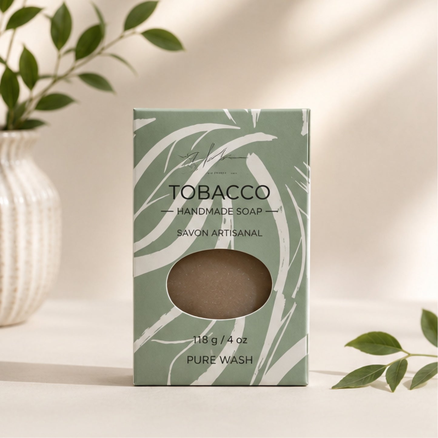 Pure Wash tobacco leaf handmade soap bar in sage green packaging with abstract white leaf print on a neutral surface.