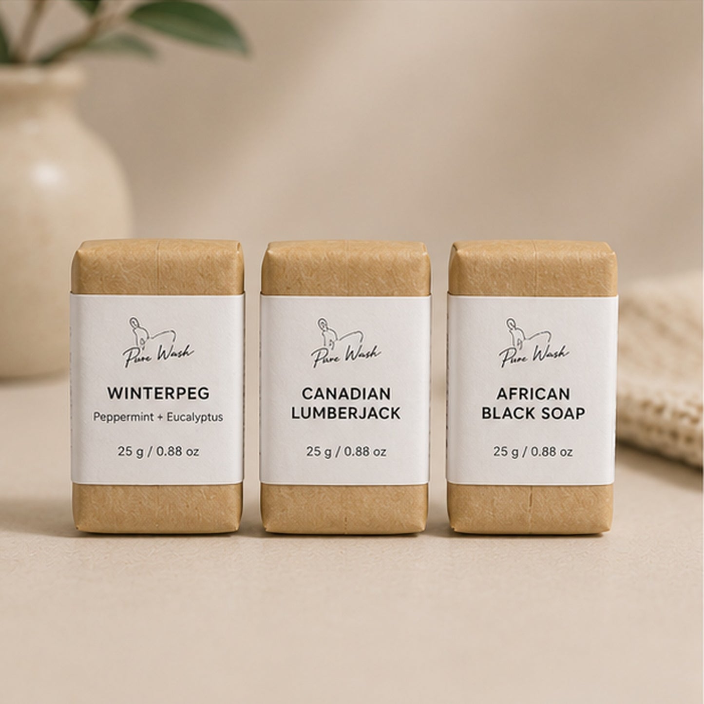 Pure Wash travel mini soap bars in kraft paper packaging with Winterpeg, Canadian Lumberjack, and African Black Soap.