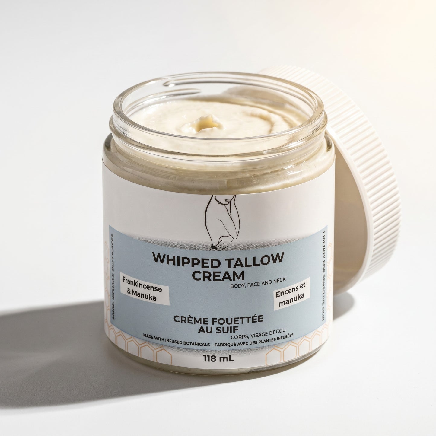 Pure Wash Frankincense & Manuka whipped tallow cream in a glass jar with an open lid on a white background.