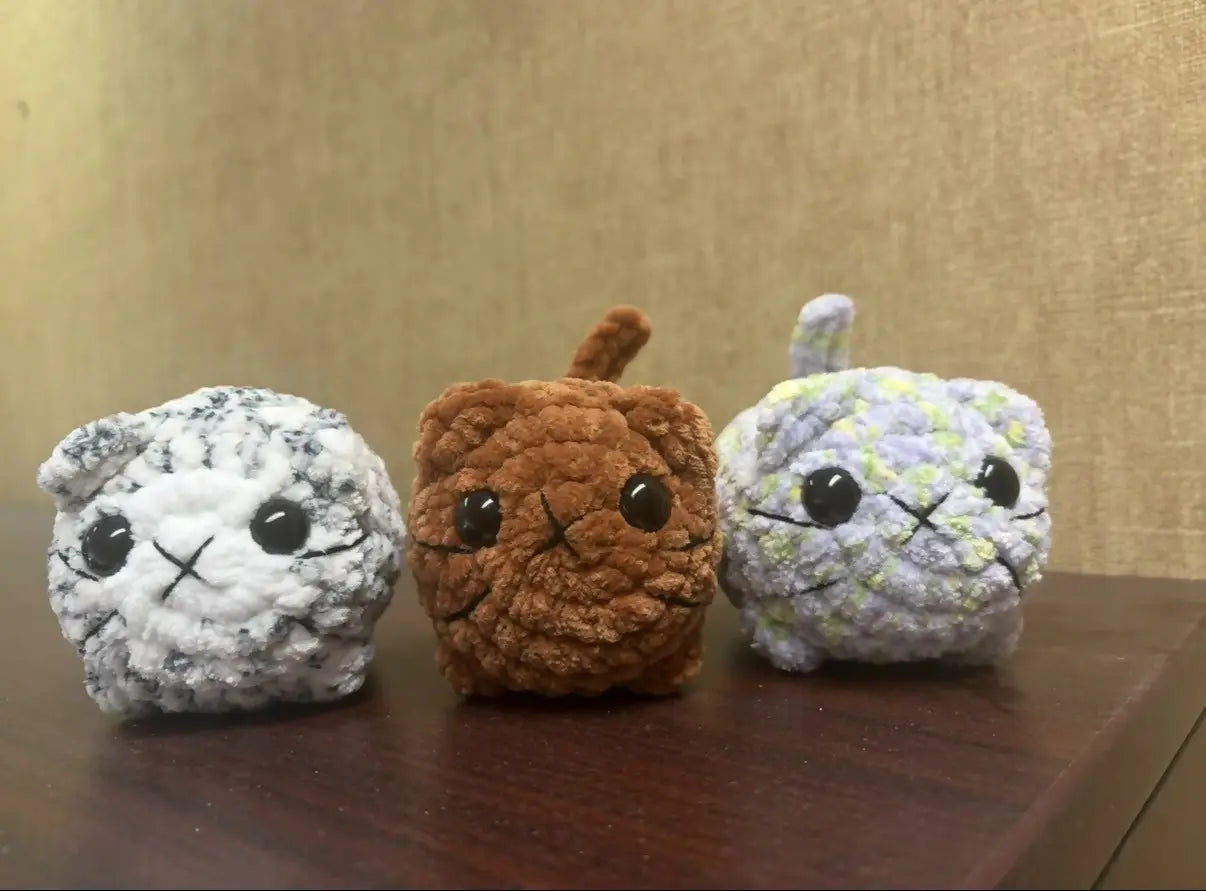 Three handmade crocheted small cats with distinct colors and small tails ideal for natural skincare canada gifts