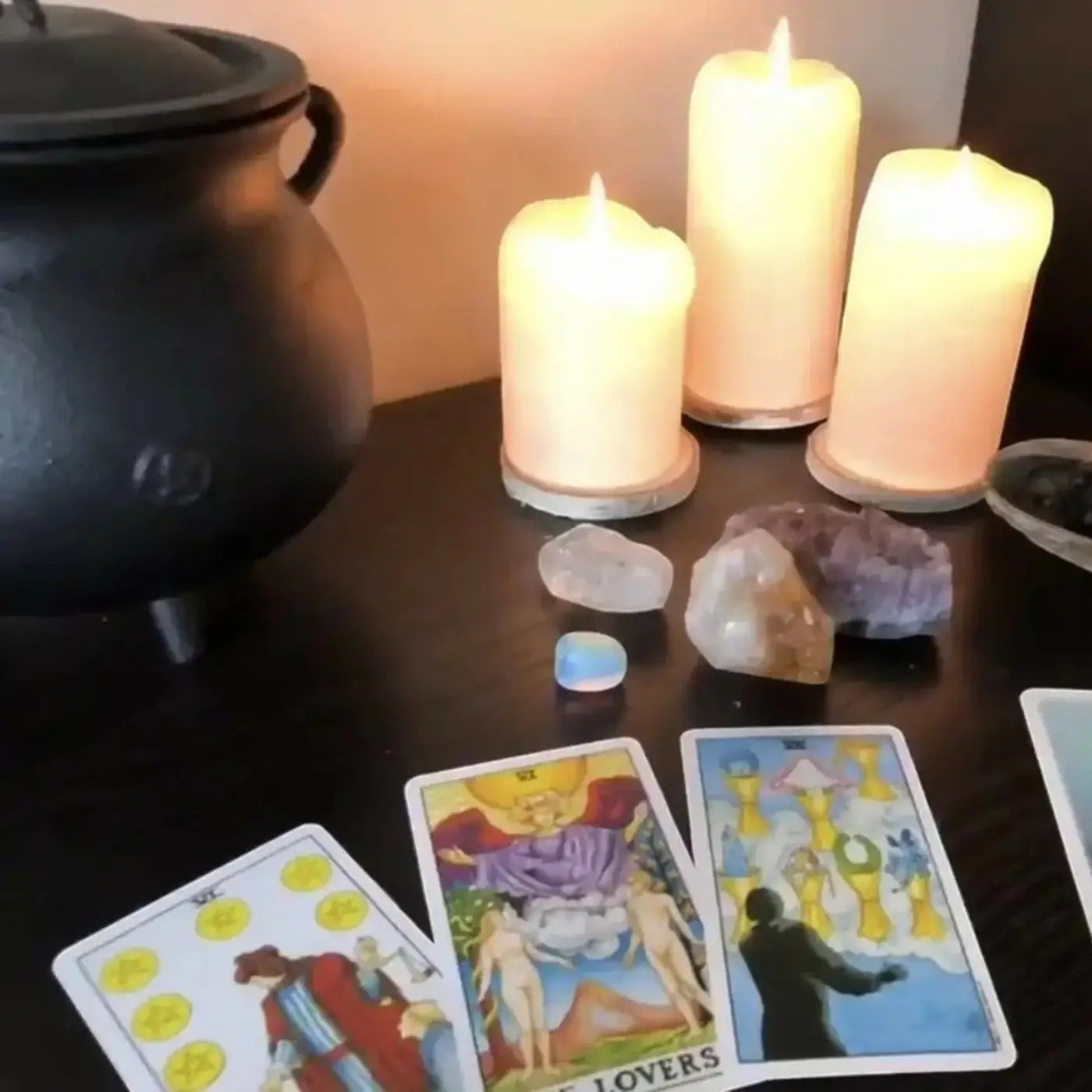 Three lit creamy-white pillar candles with smooth surfaces for tarot reading in natural skincare canada setting