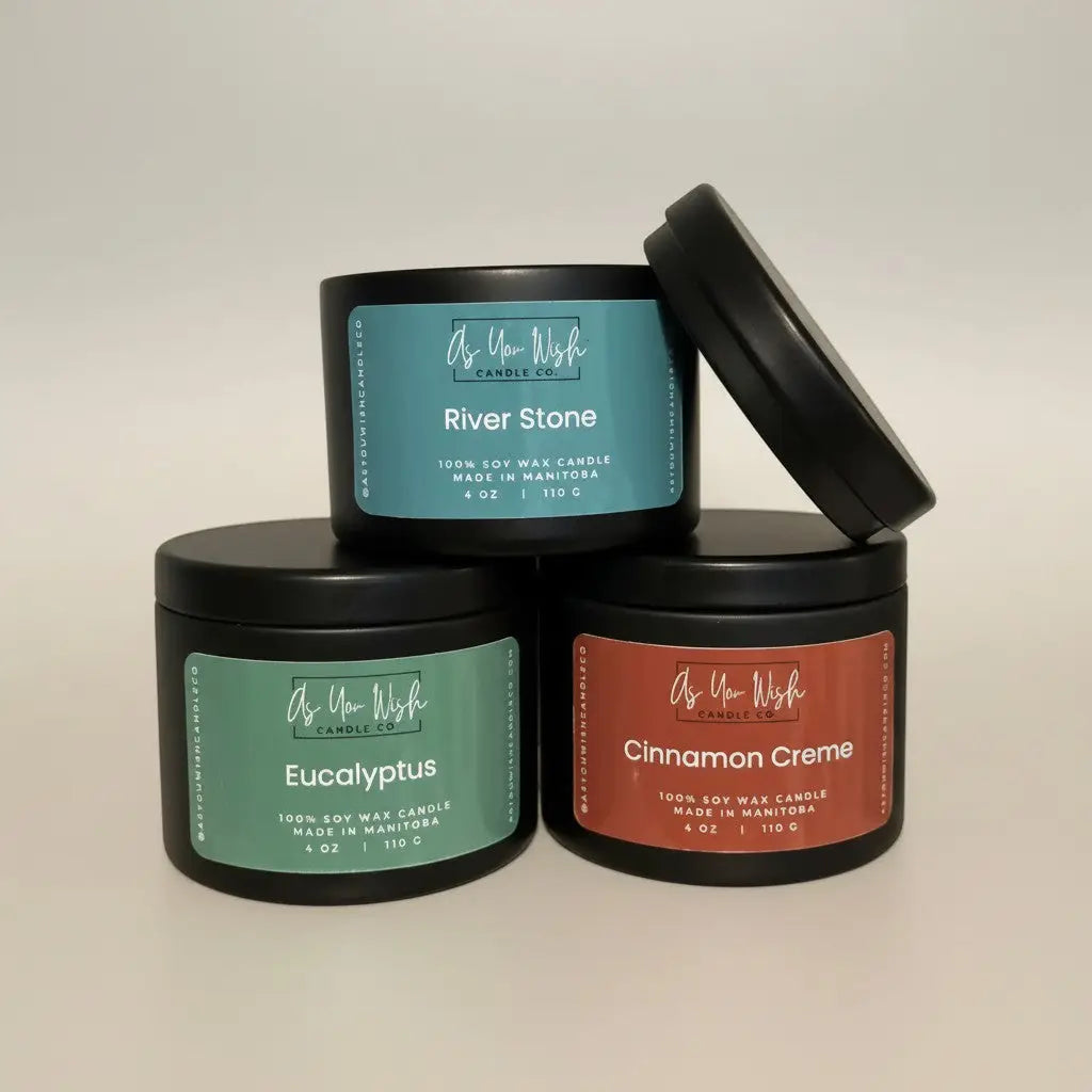 Three black cylindrical 4 oz soy candle tins with colorful labels and scents from as you wish candle co handmade soy candle canada
