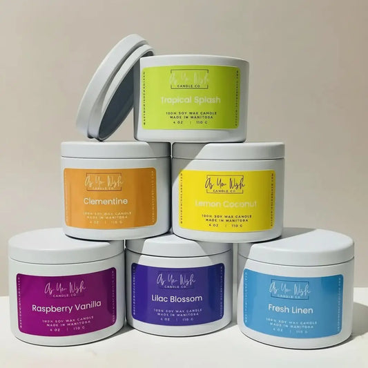 White cylindrical metal 4 oz soy candle tin with colorful labels featuring tropical splash clementine and fresh linen scents