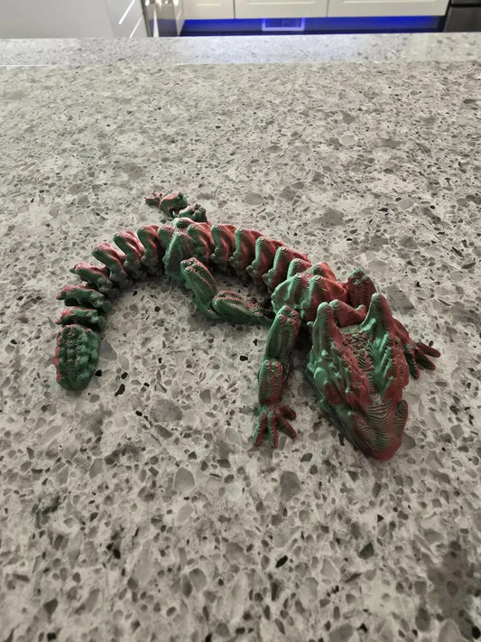 A detailed segmented 75% dragon articulated 3d printed dragon toy with textured green and red body