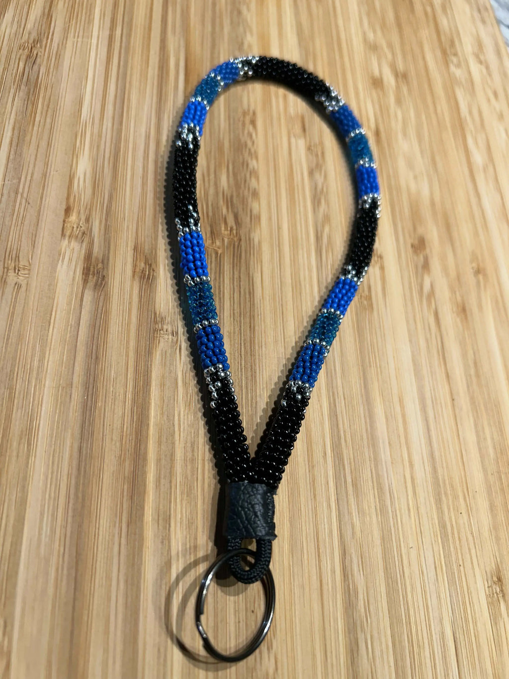 KHAOS: Beaded Wristlet Keychain with vibrant colors on black, genuine leather, 8-inch length, key ring included.