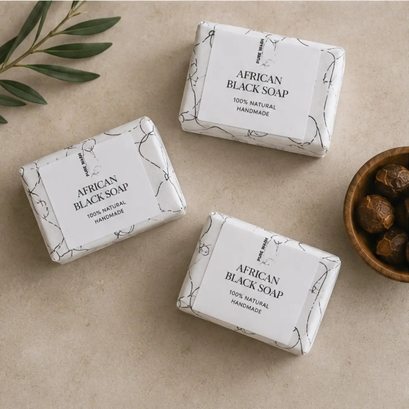Three rectangular bars of raw african black soap natural wrapped in white paper highlighting african black soap benefits for acne