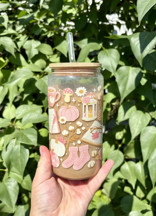 A clear glass autumn girly cup with a bamboo lid and straw decorated with pink seasonal beverage stickers