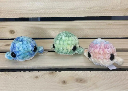 Baby whales product featuring three handmade pastel sea turtle plushies with textured yarn bodies and black button eyes