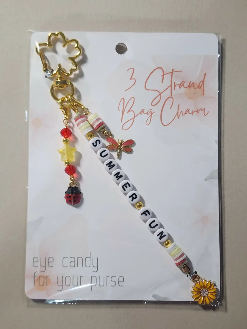 Gold-colored four-leaf clover bag charm with dragonfly ladybug sunflower beads for canadian made skincare gift accessory