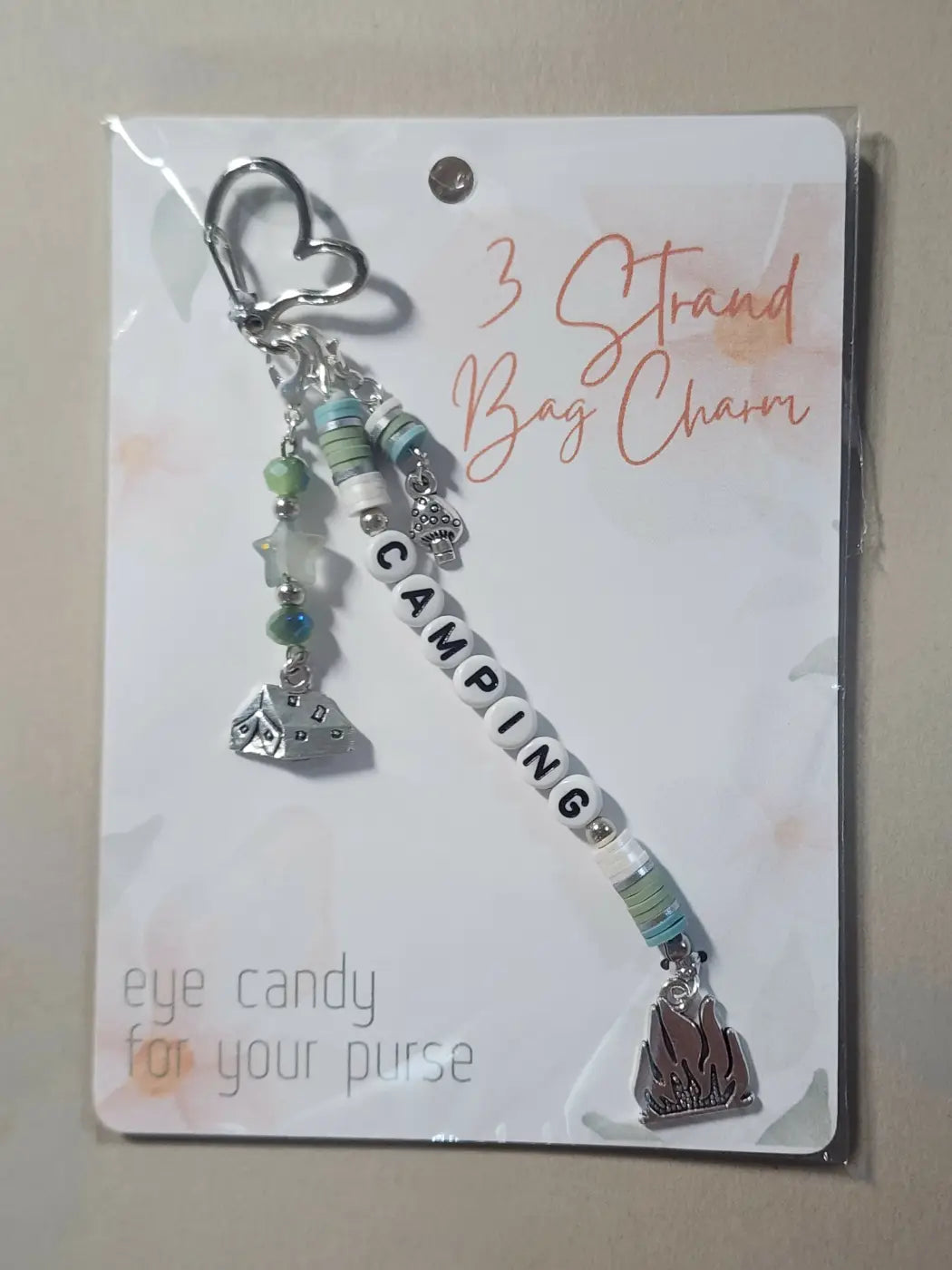 Silver heart-shaped clip bag charm with camping-themed pendants and beads, ideal for canadian made skincare accessories
