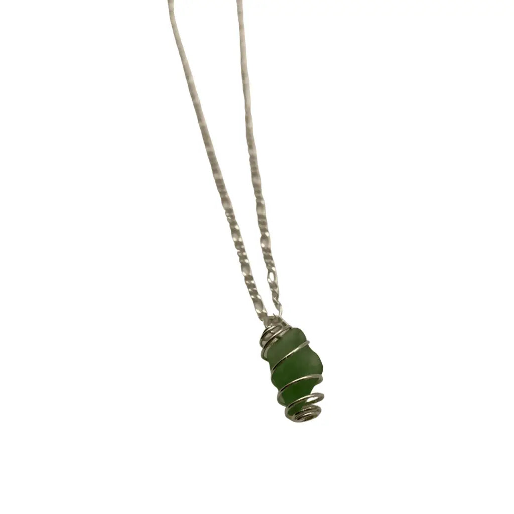 Hand-wrapped green beach glass caged pendant on a fine silver chain, shown close up.