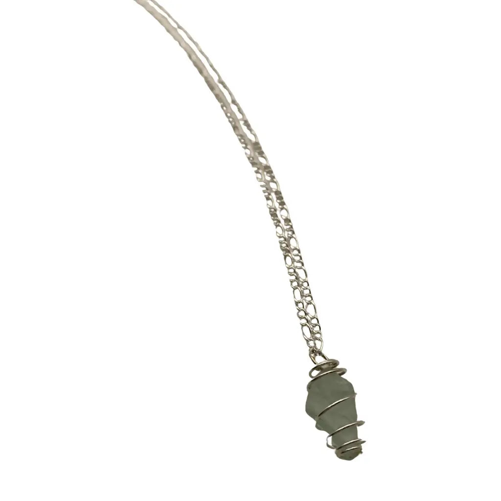 A delicate silver chain necklace with a genuine green beach glass caged pendant showcasing organic shape
