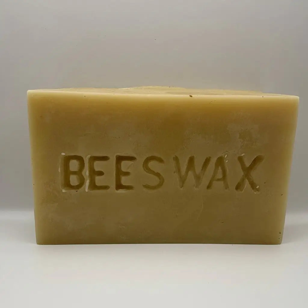 A hand poured pharmaceutical grade beeswax bar with natural honey yellow hue and embossed lettering bees wax