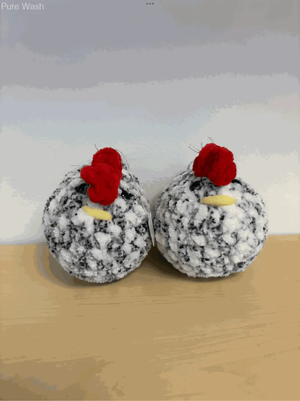 Two handmade black and white crocheted chicken plush toys with red combs yellow beaks ideal for pure wash decor