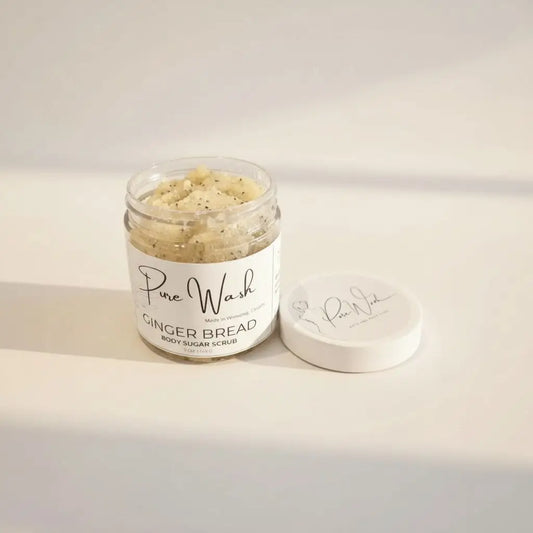 A clear glass jar of pure wash ginger bread body sugar scrub with whipped body sugar and fine cane sugar beside its lid