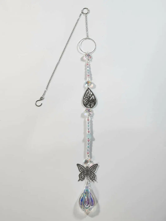 Silver-toned butterfly long suncatcher with ornate teardrop pendant, intricate leaf detailing, and crystal droplets