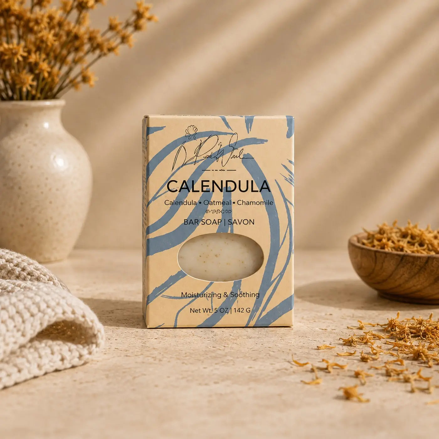 Calendula soap bar in a beige and blue patterned box with oval window showing off-white soap to support healthy skin