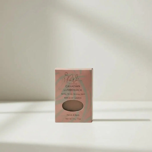 A pink rectangular box contains canadian lumberjack soap with elegant branding and a clear window showing beige handcrafted skincare bar for bathing routine