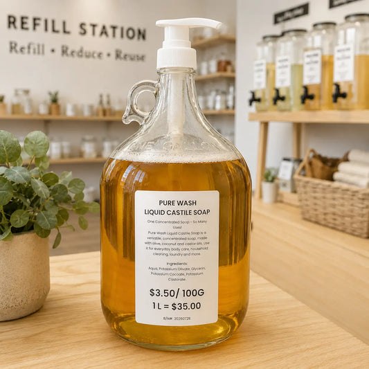 Clear glass jug with white pump filled with amber castile soap for natural skincare canada refill in-store
