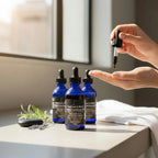 Deep blue glass bottles with black dropper caps containing charcoal and black seed clarifying oil for dark spots and balances sebum production