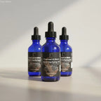 Three cobalt blue glass dropper bottles of charcoal and black seed clarifying oil to balance sebum and reduce dark spots