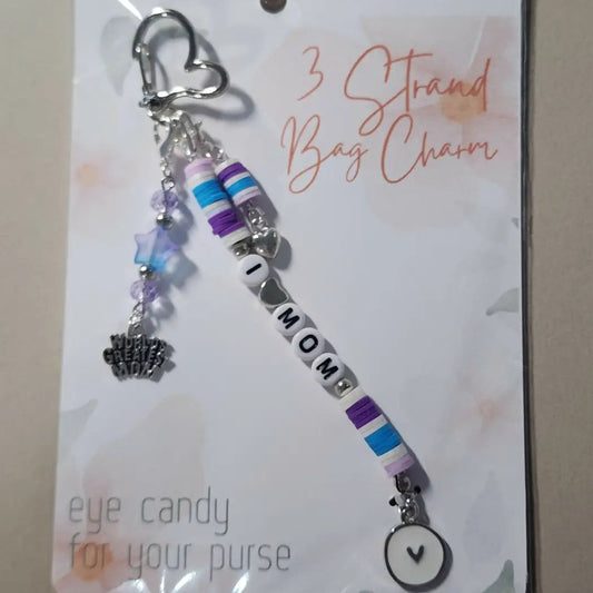Charm 15 features a delicate silver heart clip attached to a handmade beaded bag charm with purple blue and white strands