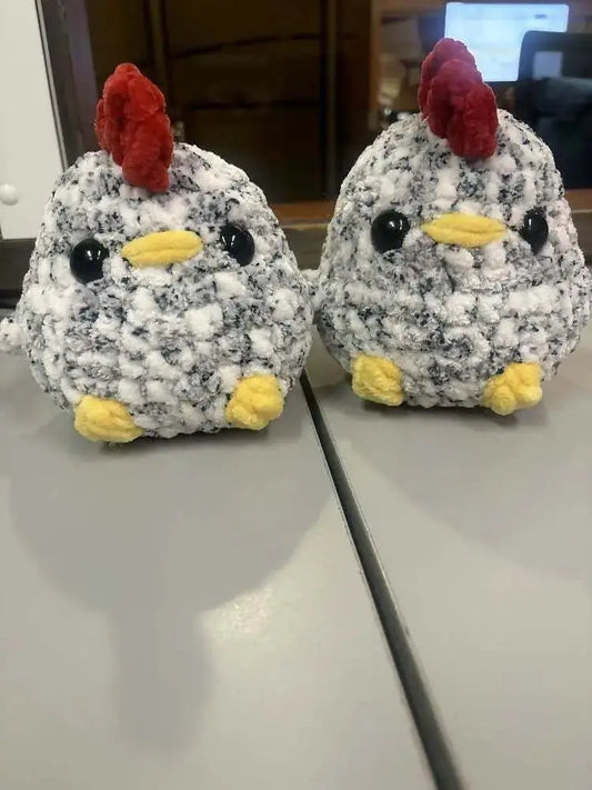 Two handmade crocheted chonky chickens plushies in black white with red combs perfect for pure wash handmade soap canada display