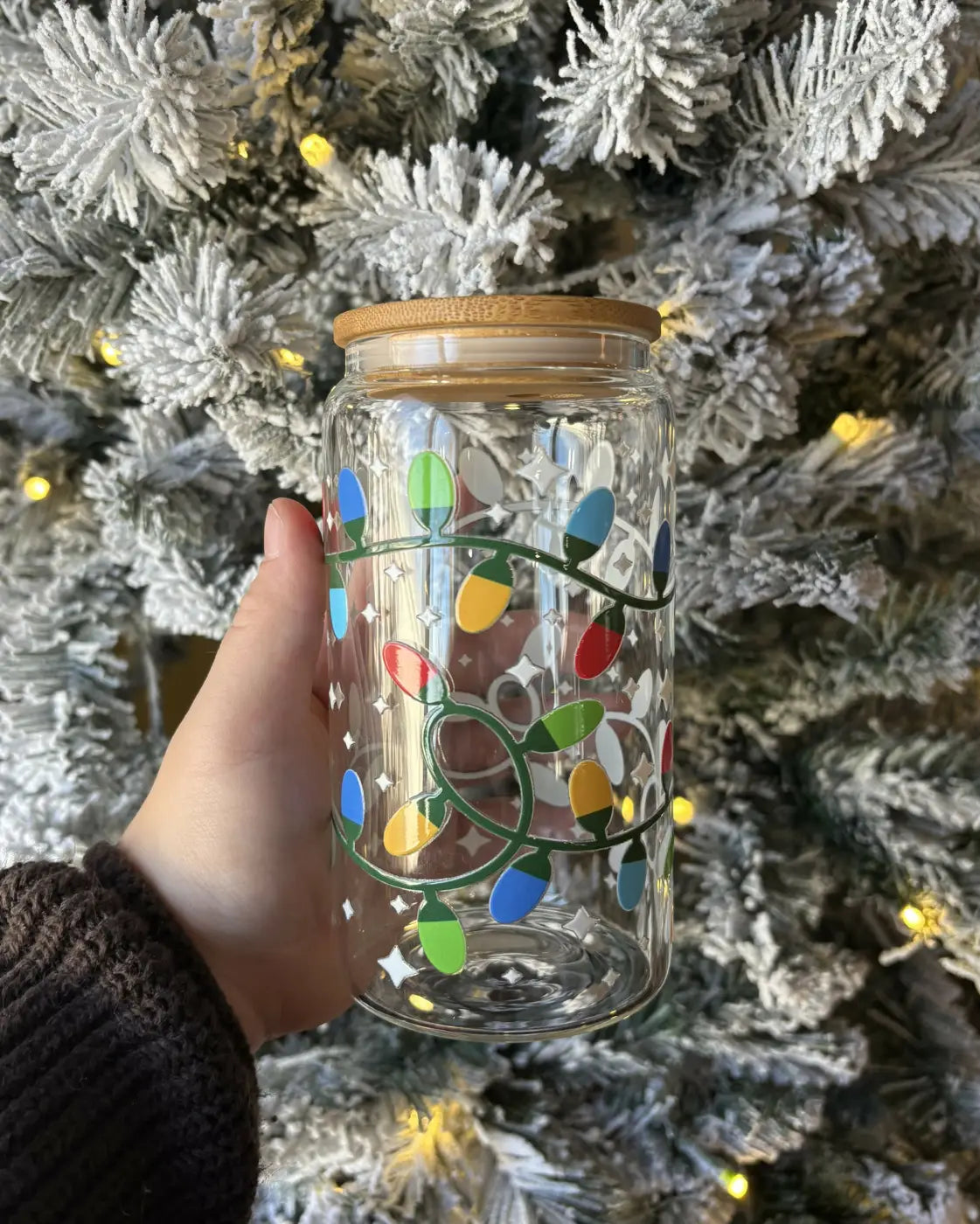 Clear glass jar with colorful christmas lights and a stylish bamboo lid featuring reusable glass straw and dtf decals