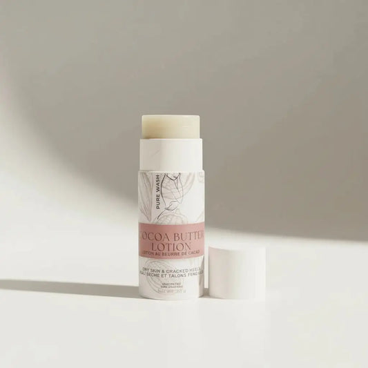 A sleek white cylindrical tube of cocoa butter lotion with a soft pink label and an off-white balm stick featuring sweet almond oil