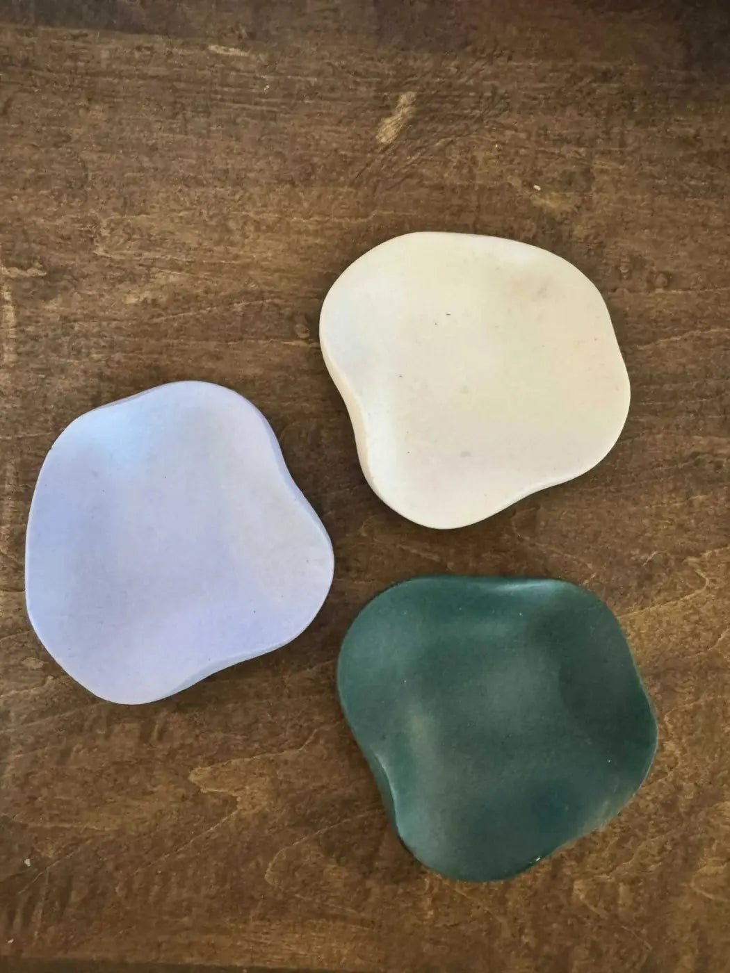 Three curvy ring holder ceramic soap dishes in organic shapes and soft lavender creamy white and deep teal hues