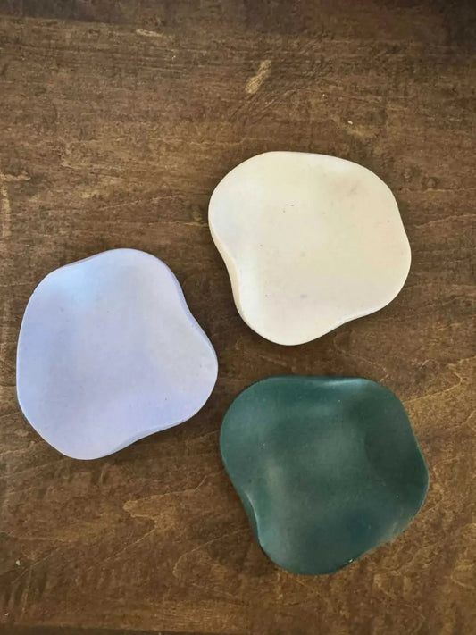 Three curvy ring holder ceramic soap dishes in organic shapes and soft lavender creamy white and deep teal hues