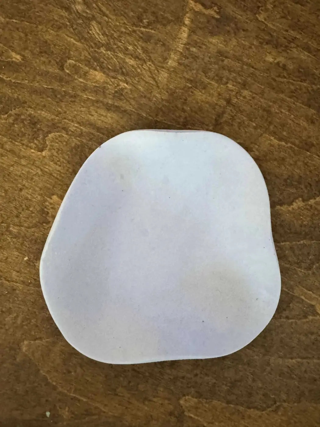 White smooth ceramic curvy ring holder with rounded edges and slightly irregular shape for ring storage