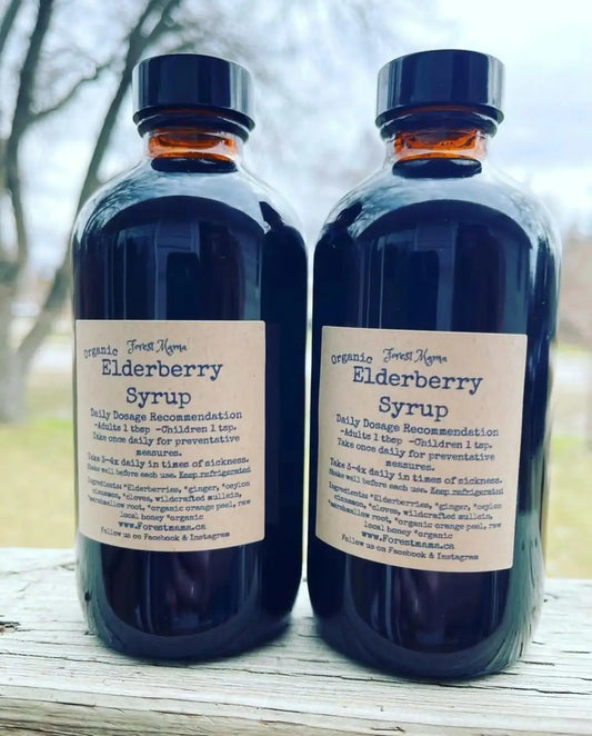 Two dark amber glass bottles of organic elderberry syrup with beige labels for flu season and pure wash use