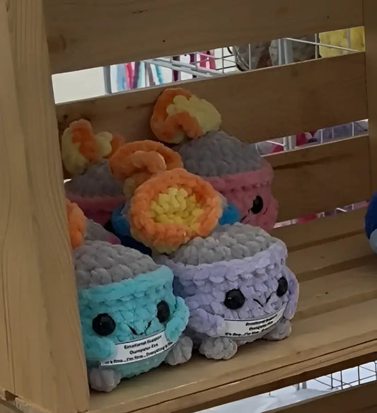 Cute crocheted emotional support dumpster plush toys with round faces and colorful yarn bodies for comfort and support