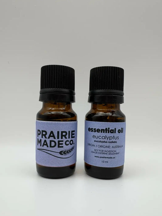 Two amber glass 10 ml essential oils bottles with black caps and purple labels from prairie made co. for natural skincare canada