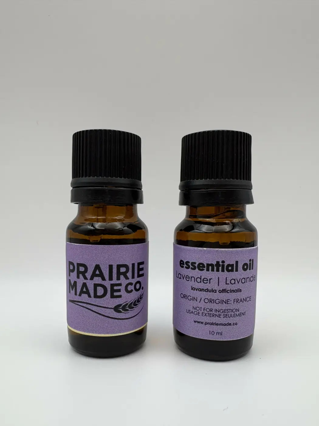 Two amber glass essential oils bottles with lavender labels from prairie made co for natural skincare canada use