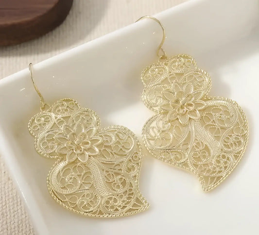 Gold-toned filigree earrings featuring vintage hollow carved heart design with intricate floral lace detailing