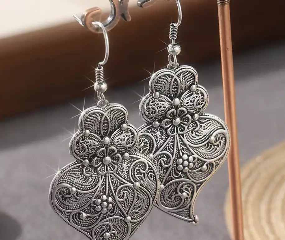 Silver filigree heart earrings with intricate floral and vine detailing in delicate maxi-hook style
