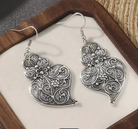 Silver filigree heart earrings with intricate floral paisley patterns and small beads in delicate maxi‑hook style