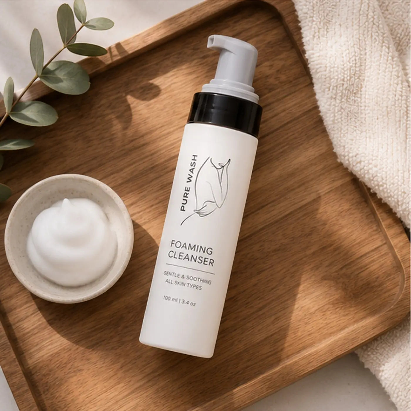 White cylindrical bottle of pure wash foaming hand soap with black pump dispenser and minimalist line art label