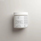 White cylindrical jar of manuka tallow cream with ribbed lid and minimalist label for skin barrier and shea butter care