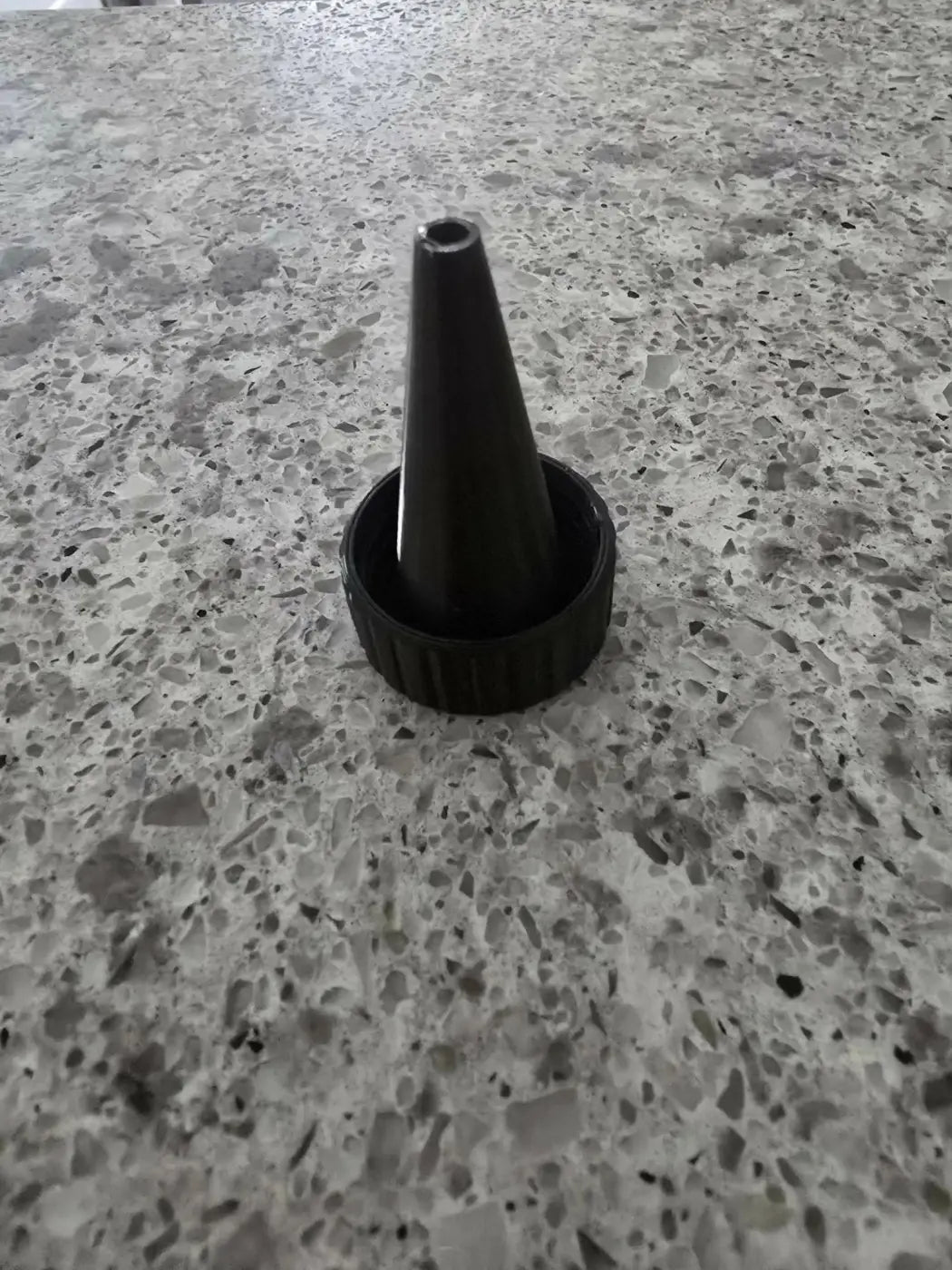 Black plastic bottle cap with conical nozzle for fruit fly trap designed to capture and control fruit flies efficiently