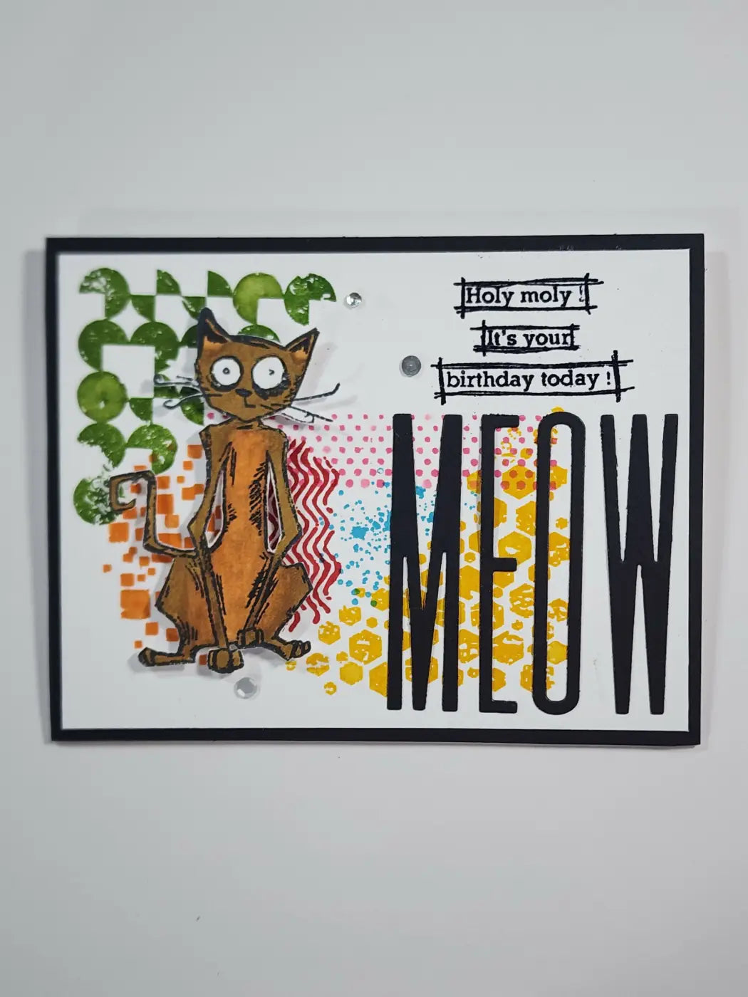 A whimsical brown cartoon cat on a handmade birthday card with colorful patterns perfect for canadian made skincare gifts